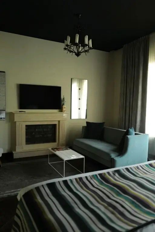 Wohnbereich mit Kamin, Sofa und stilvollem Tisch in der Suite