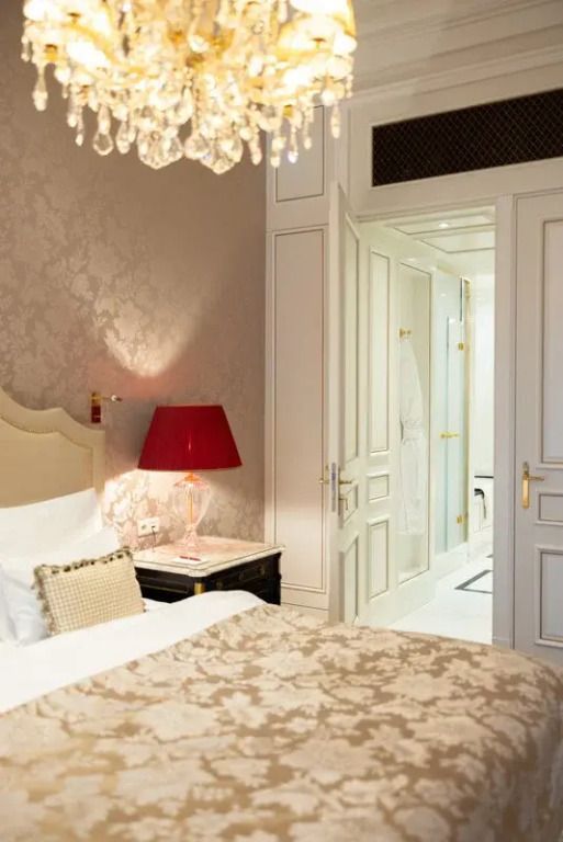 Gemütliches Schlafzimmer mit edler Tapete und roter Tischlampe