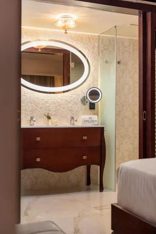 Stilvolles Badezimmer mit eleganter Holzkommode und großem Spiegel