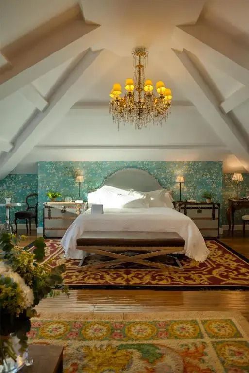 Elegante Suite mit Doppelbett, blumiger Tapete und opulentem Kronleuchter
