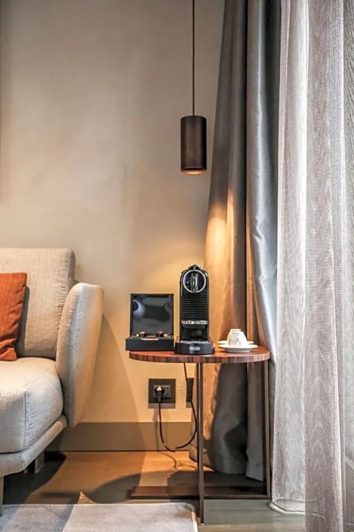 Kuschelige Ecke mit Kaffeemaschine neben einem Sofa im Hotelzimmer