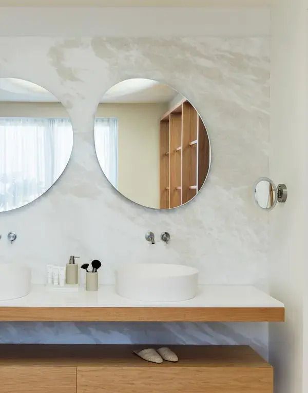 Doppelwaschbecken im Badezimmer mit runden Spiegeln und viel Licht