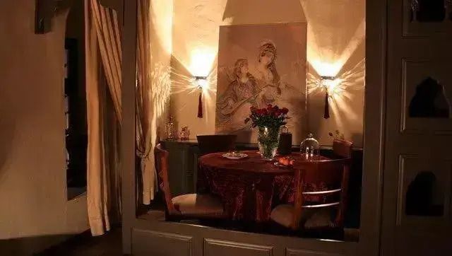 Stimmungsvoller Essbereich mit eleganten Leuchten und Kunstwerk im Hintergrund.