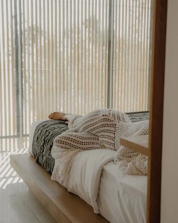 Luxuriöses Bett im Deluxe Zimmer mit natürlichem Licht und modernem Design.