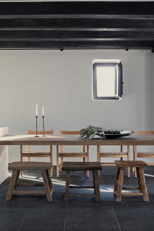 Minimalistischer Essbereich mit Holztisch und Hockern in einer Villa