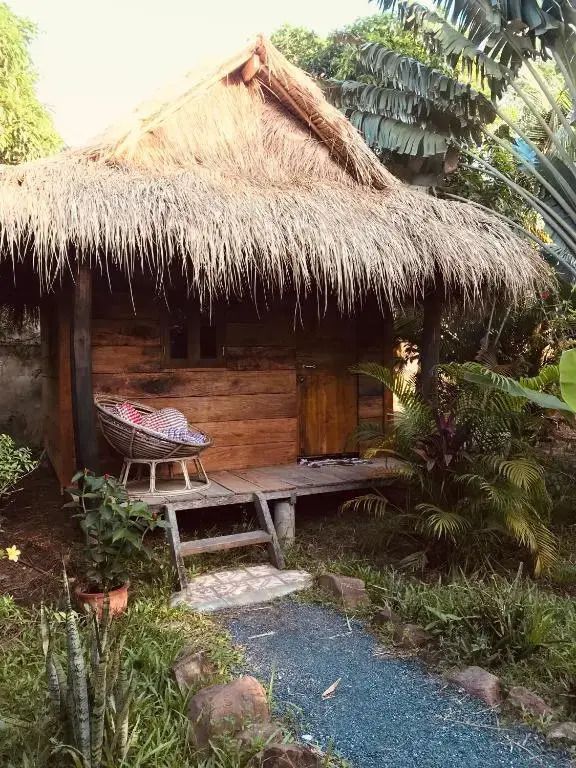 Ruhiger Bungalow mit Strohdach umgeben von üppigem Garten