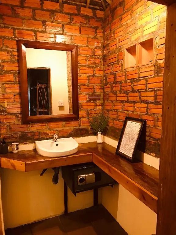 Badezimmer mit Backsteinwand Spiegel und stilvollem Waschbecken