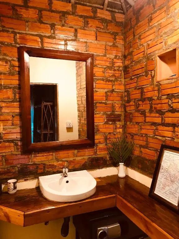 Nahaufnahme eines Badezimmers mit Spiegel und Backsteinwand