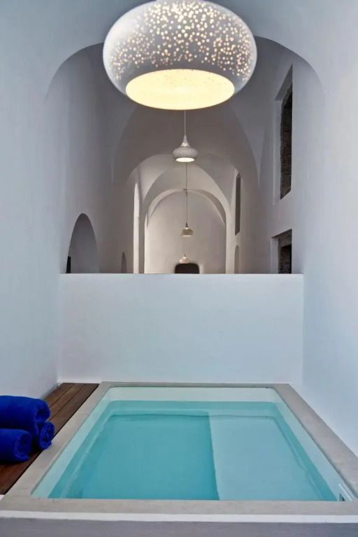 Innenpool in minimalistischer Architektur mit weißen Wänden und moderner Beleuchtung