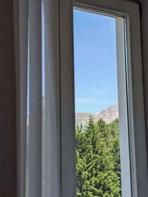 Panoramablick aus dem Fenster auf Berge und Bäume