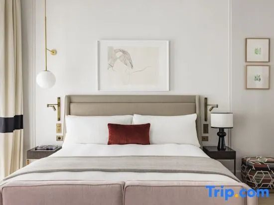 Modernes Doppelbett mit Kunstwerk und eleganten Lampen im Hotelzimmer