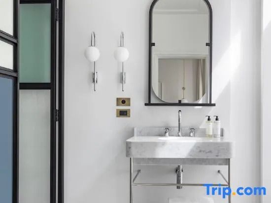 Badezimmer mit ovalem Spiegel und Doppelwandlampen in elegantem Design