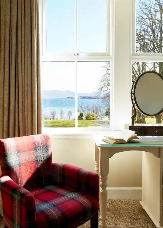 Zimmer mit Blick auf den See und einem roten Sessel am Fenster