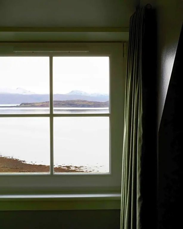 Panoramafenster mit Blick auf See und Berge.
