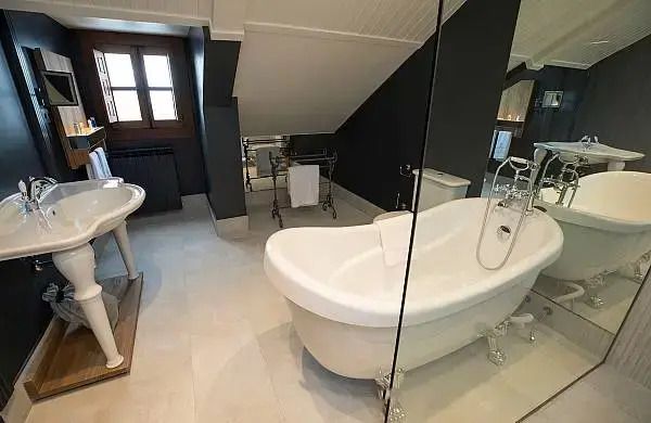 Luxuriöses Badezimmer mit freistehender Badewanne und Dachfenster.