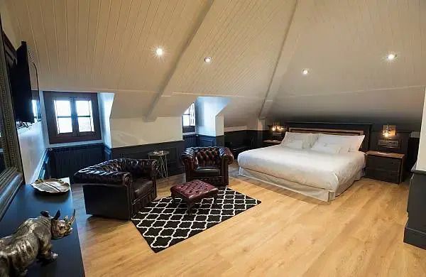 Dachgeschosszimmer mit Doppelbett und gemütlicher Sitzecke