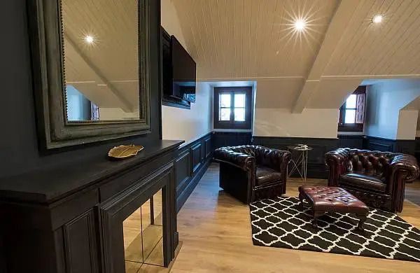 Zimmer mit Kamin und moderner Einrichtung unter Dachschrägen