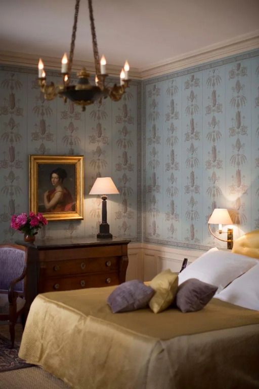 Luxuriöses Zimmer mit antikem Mobiliar und stilvollem Porträt an der Wand.