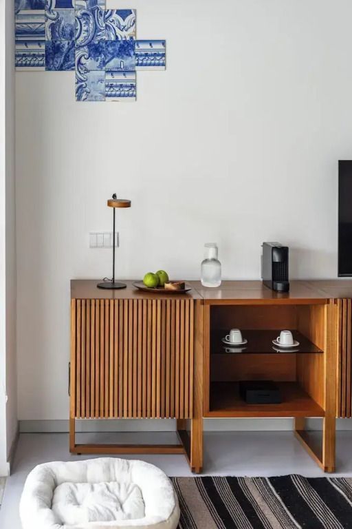 Schrank aus Holz mit Kaffeemaschine und Tassen, schlichtes Dekor.