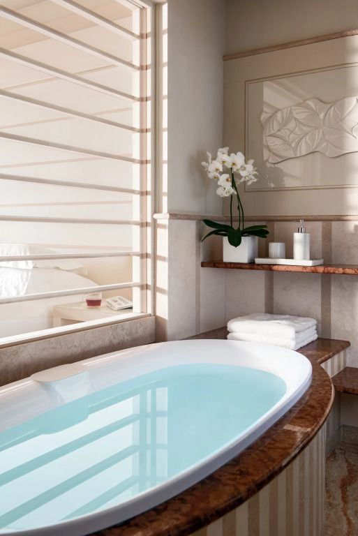 Luxuriöses Badezimmer mit einer gefüllten Badewanne und dekorativen Elementen