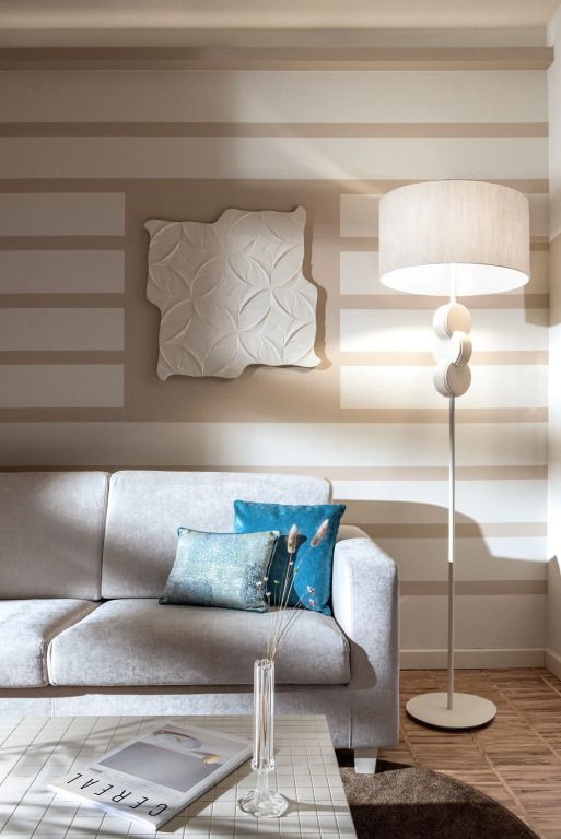 Gemütliche Sitzecke mit eleganter Stehlampe und moderner Kunst an der Wand.