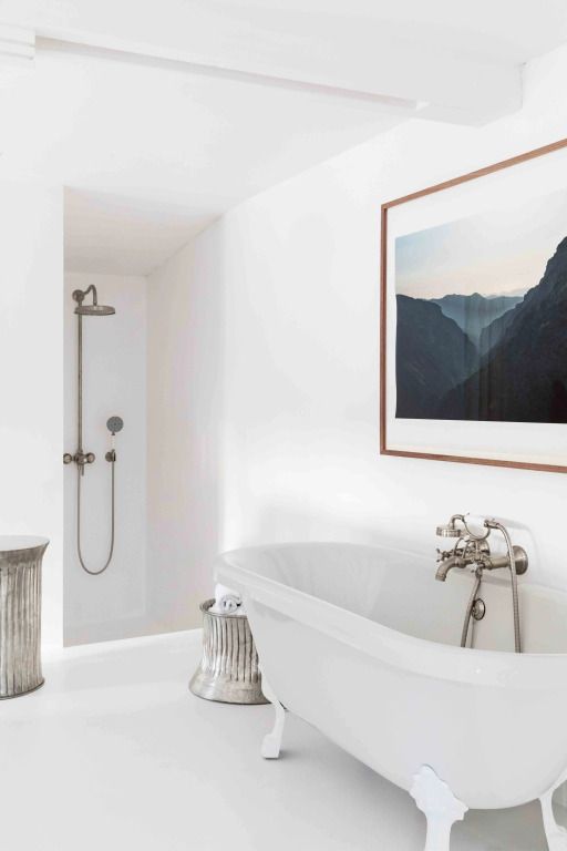 Elegantes Badezimmer mit freistehender Badewanne und Wandbild