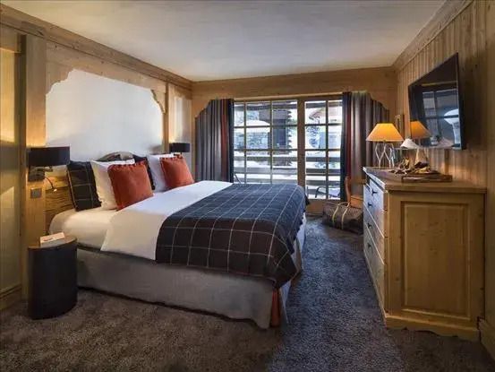Gemütliches Schlafzimmer mit Doppelbett und großen Fenstern