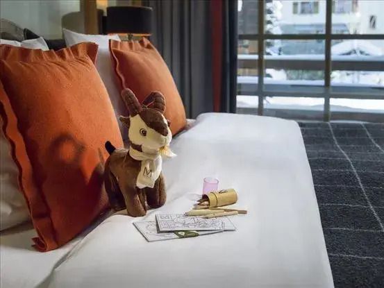 Doppelbett mit Dekoration und Kuscheltier im Hotelzimmer
