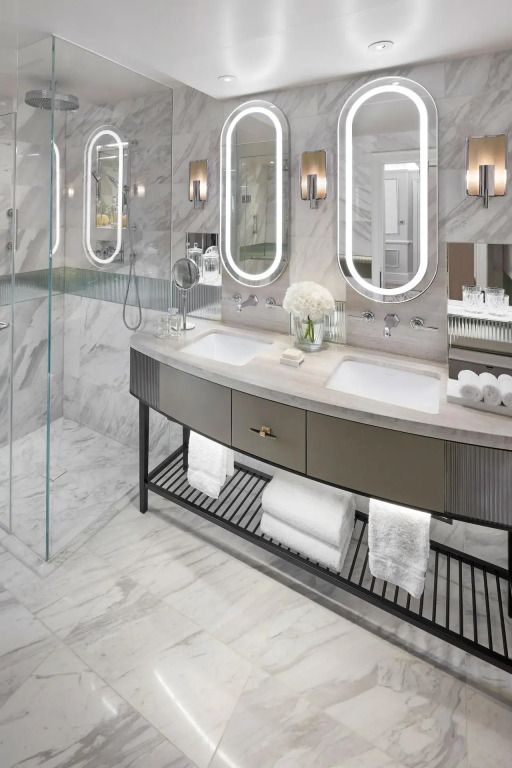 Modernes Badezimmer mit Doppelwaschbecken, Spiegeln und Marmorwänden in der Knightsbridge Suite.
