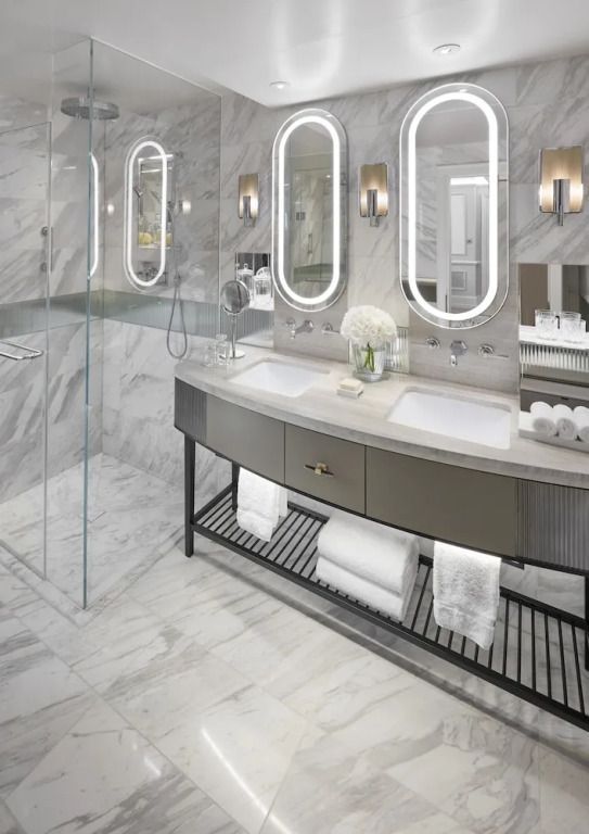 Modernes Badezimmer mit zwei Waschbecken, großen Spiegeln und eleganten Details