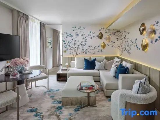 Elegante Suite mit luxuriösem Sofa und stilvolle Wanddekorationen mit Blütenmotiv
