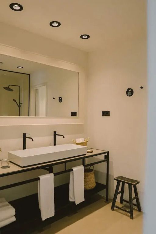 Modernes Badezimmer mit schlichtem Dekor und großem Spiegel