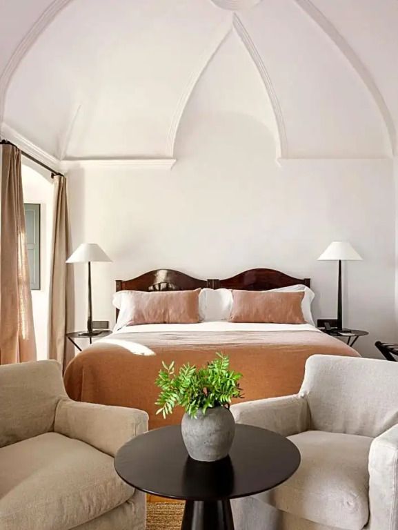 Helles Schlafzimmer mit Doppelbett und Tisch mit Pflanze