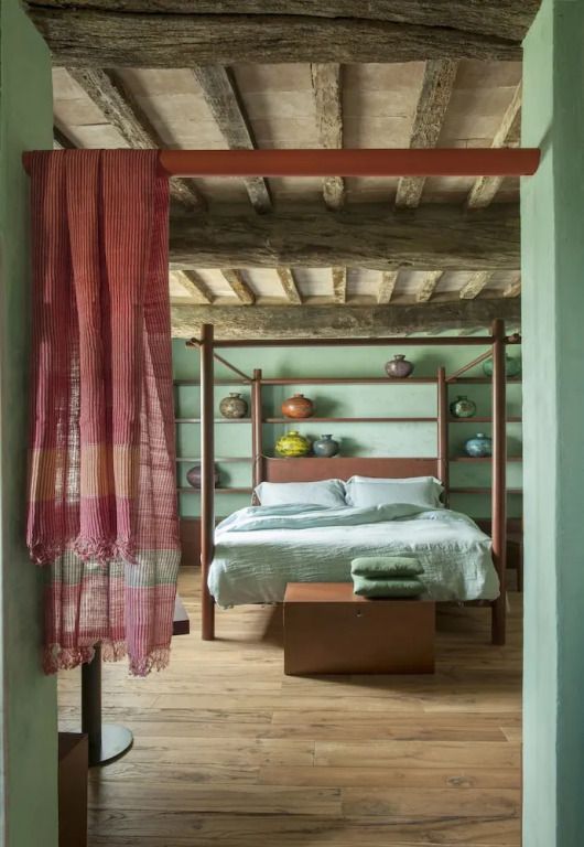 Gemütliches Schlafzimmer mit farbigen Akzenten und sichtbaren Holzbalken.