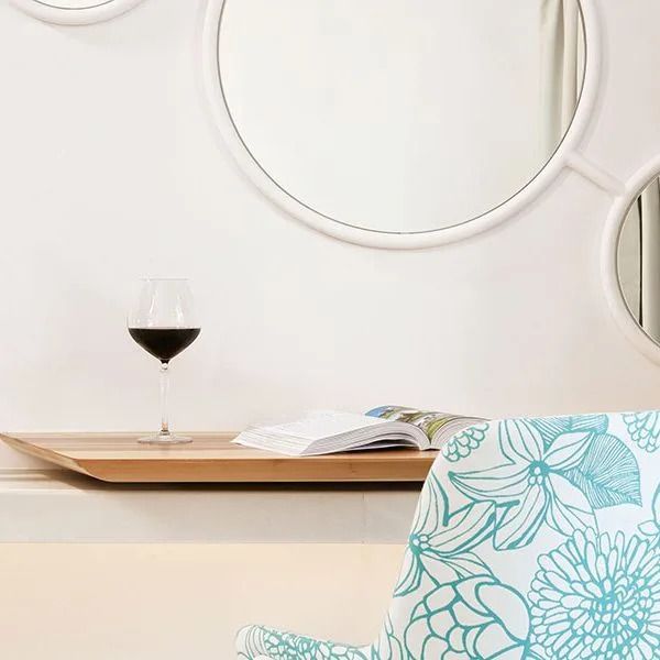 Detailansicht eines Loungebereichs mit Wein und stilvoll gestaltetem Sessel.