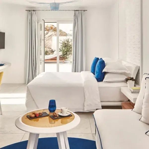 Helle Suite des Myconian Ambassador Hotels mit Doppelbett und moderner Einrichtung
