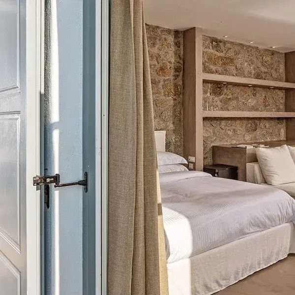 Gemütliche Suite mit Steinwand und eleganten Möbeln in neutralen Tönen.