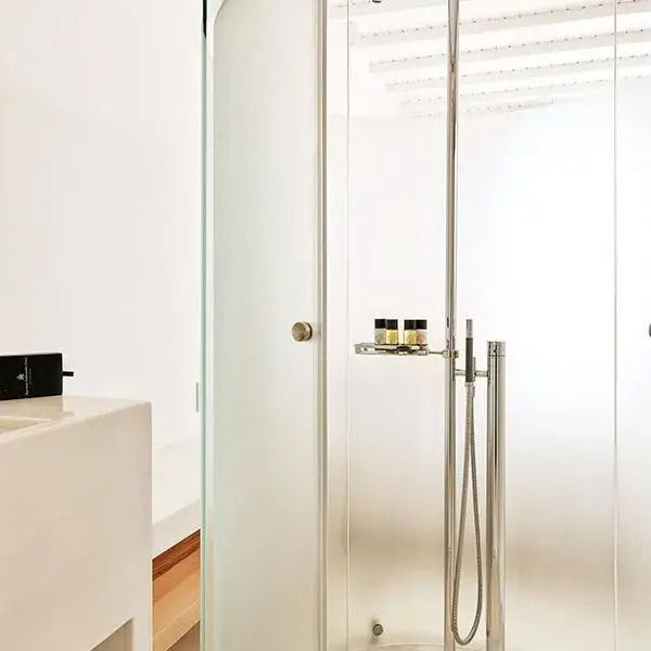 Modernes Badezimmer mit eleganter, gläserner Dusche und minimalistischem Design.