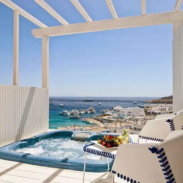 Outdoor-Whirlpool mit Blick auf das blaue Meer und den Hafen.