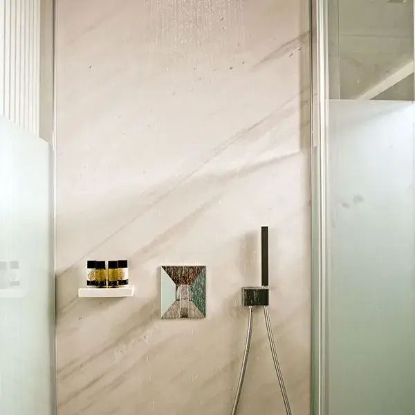 Elegante Duschwand mit modernen Armaturen und sanften Grautönen.