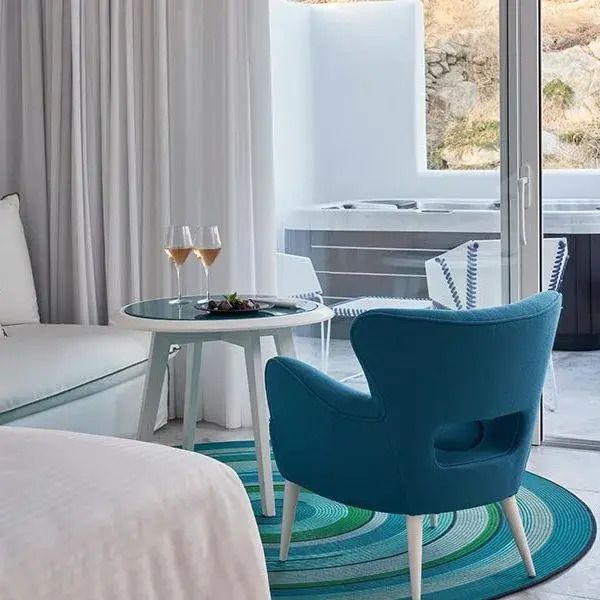 Elegantes Zimmer mit Sitzbereich und direktem Zugang zu einem privaten Außenpool