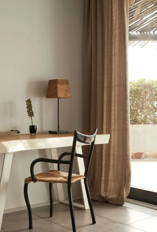Arbeitsbereich mit Schreibtisch und Stuhl bei natürlichem Licht