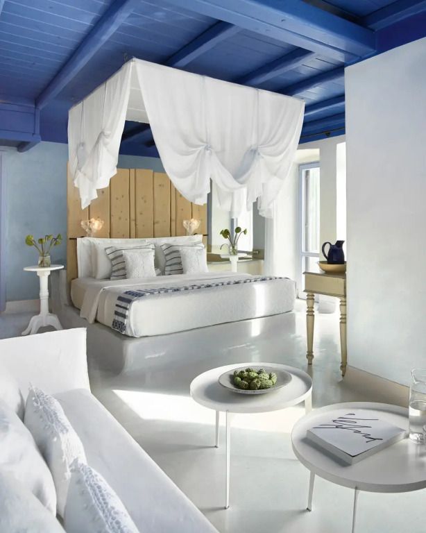 Elegantes Schlafzimmer mit Himmelbett, hellem Dekor und blauen Akzenten