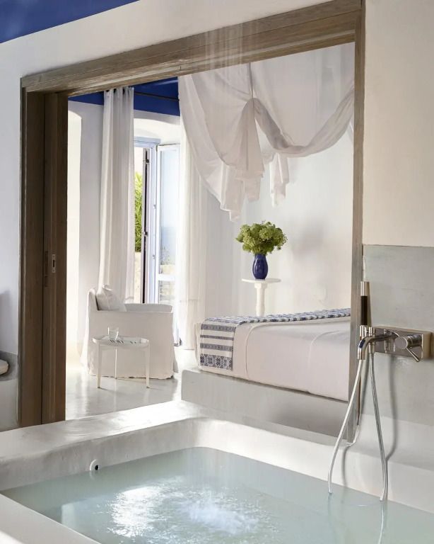 Freistehende Badewanne mit Blick ins Schlafzimmer durch offene Schiebetür