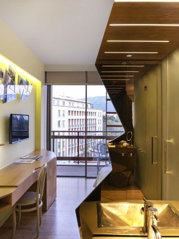 Schickes Hotelzimmer mit Schreibtisch, moderner Ausstattung und Stadtpanorama.