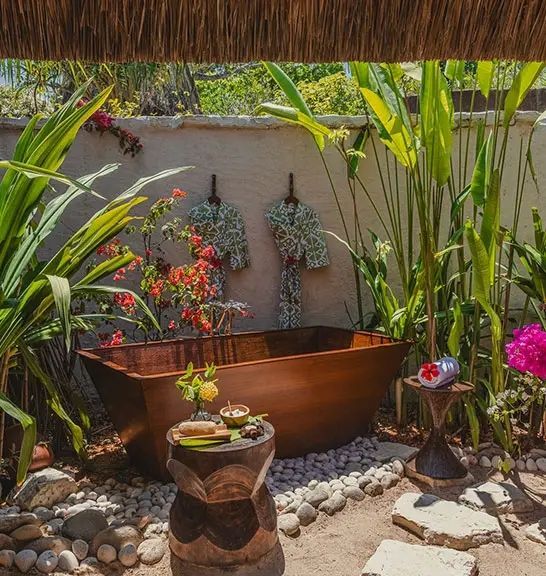 Freiluft-Badewanne im Garten mit tropischen Pflanzen und natürlicher Umgebung