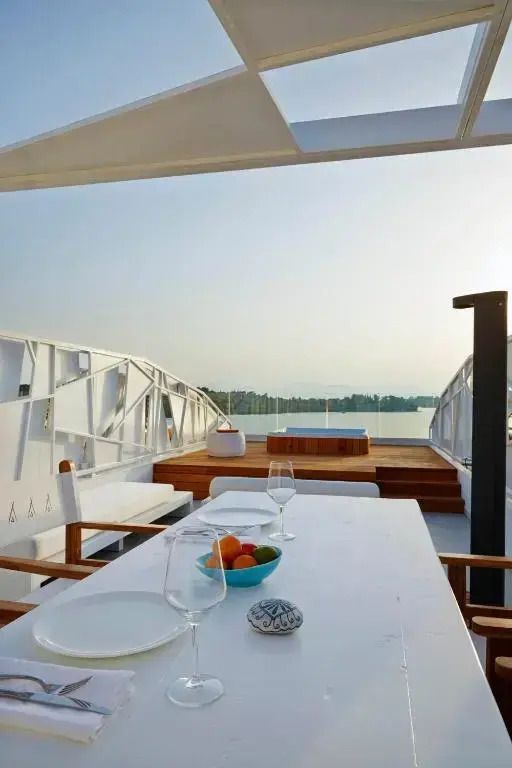 Terrasse mit Esstisch und Blick auf das Meer im Abendlicht