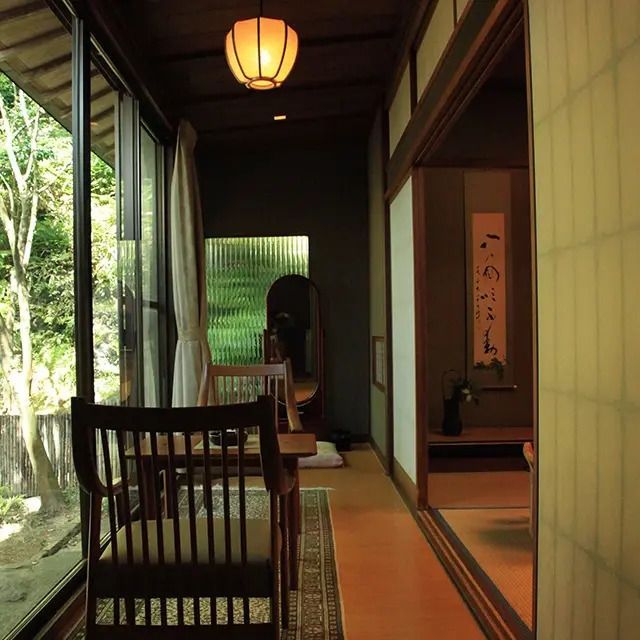 Schmaler Korridor mit traditionellen japanischen Elementen und Fensterblick auf den Garten
