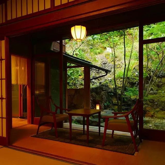 Gemütliche Sitzecke im japanischen Stil mit Blick auf einen grünen Garten.