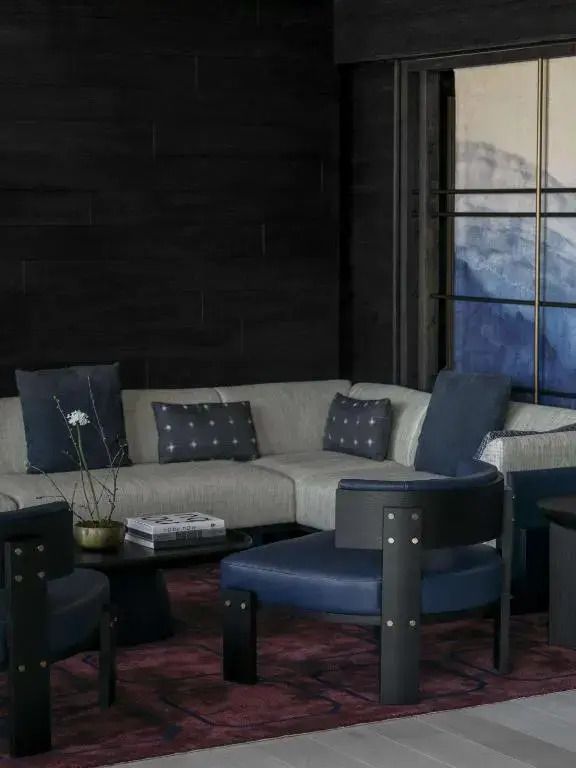 Gemütliche Sitzecke mit grauem Sofa und blauen Sesseln